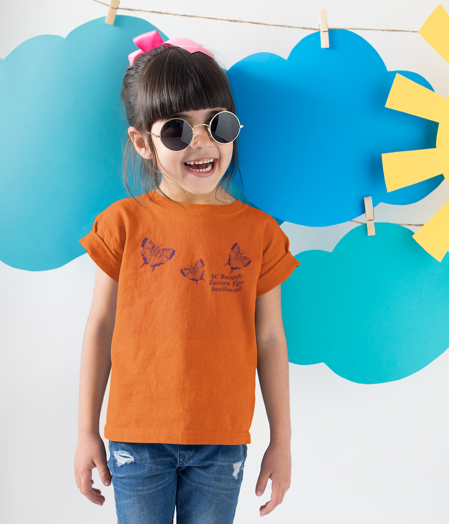 Little girl with round sunglasses and jeans with an orange adder T-shirt with t